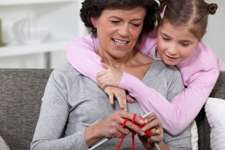 A mom showing how to knit to her daughter.の写真素材