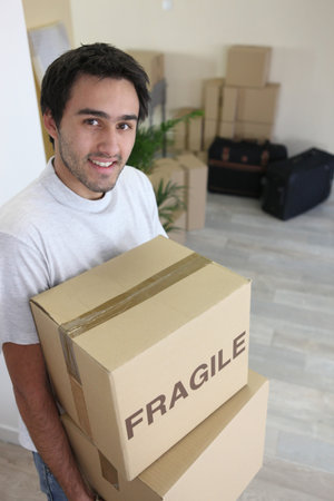 Young man moving boxes marked f