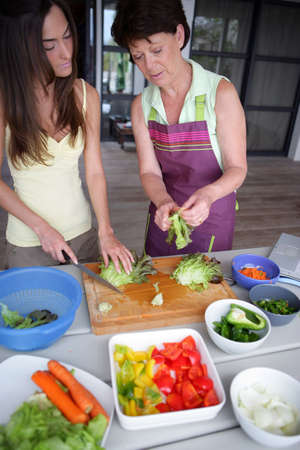 Mother and daughter preparing vegetablesの写真素材