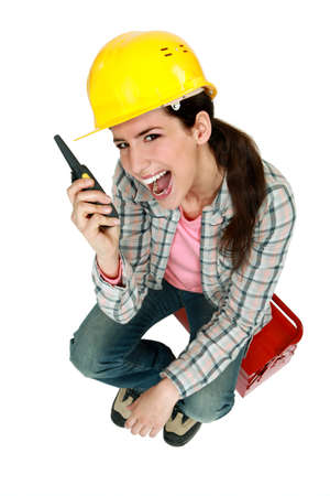 Female construction worker yelling into a walkie-talkieの写真素材