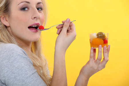 Woman eating fruit cocktailの写真素材