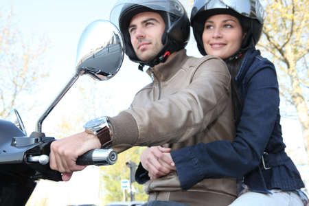 Couple riding a scooterの写真素材