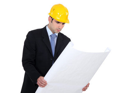 Mae architect examining plans