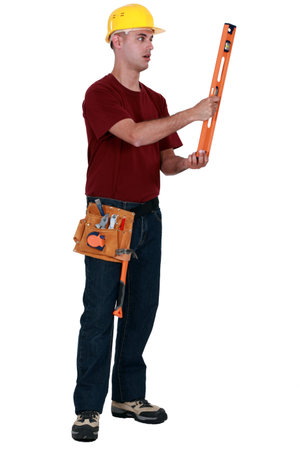 A handyman staring at a level.