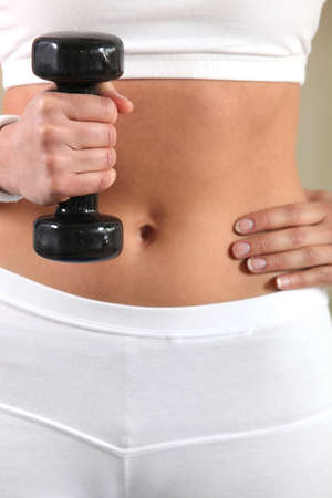 Close-up of woman holding gym weightの写真素材