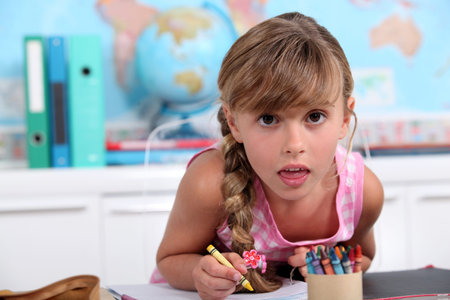 Little girl drawing with crayons