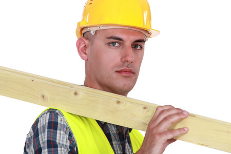 Labourer carrying a wooden plank