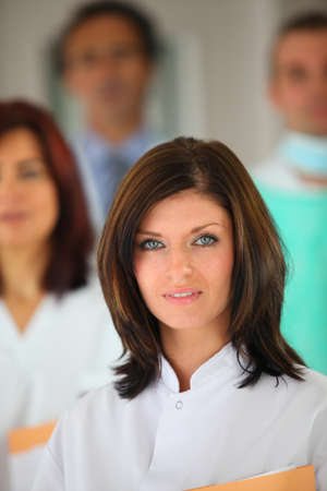 portrait of young female background with medical team in backgroundの写真素材