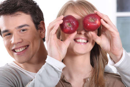 young man holding red apples before girfriendの写真素材
