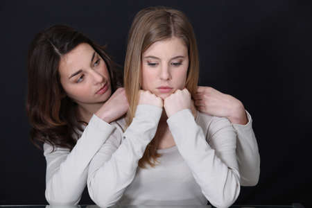 A teenage girl trying to cheer up her friend.の写真素材