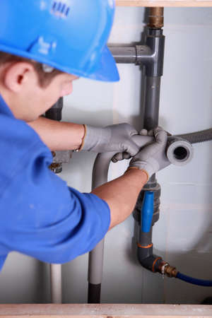 Plumber installing plastic domestic water pipesの写真素材