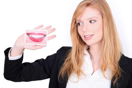 girl with picture of a mouth in handの写真素材