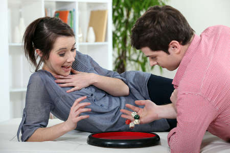 Young couple playing with diceの写真素材