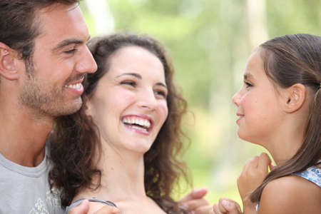 Close up of parents laughing with daughterの写真素材
