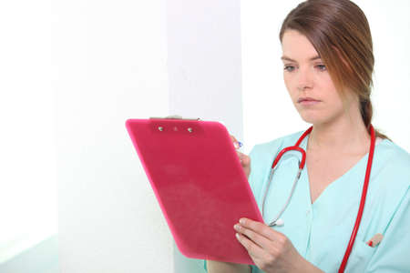 Nurse looking at clipboardの写真素材