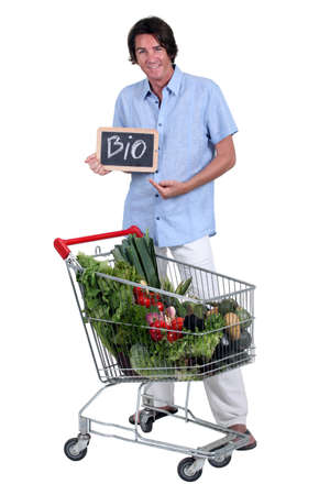 Man with a shopping trolley of organic produceの写真素材
