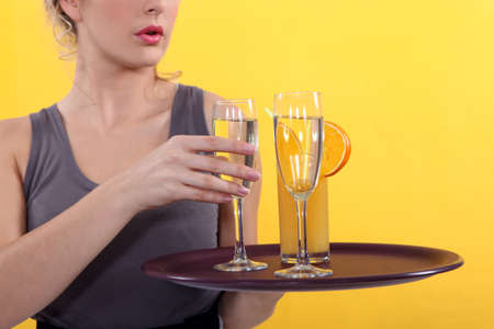 Casual waitress with a tray of drinksの写真素材