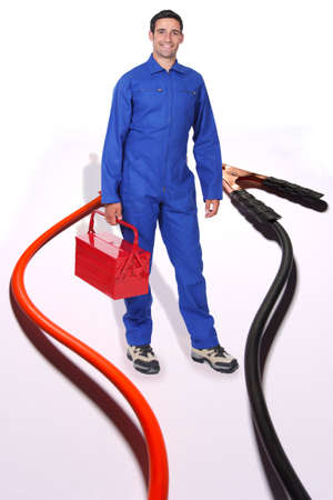 Tradesman surrounded by jumper cablesの写真素材