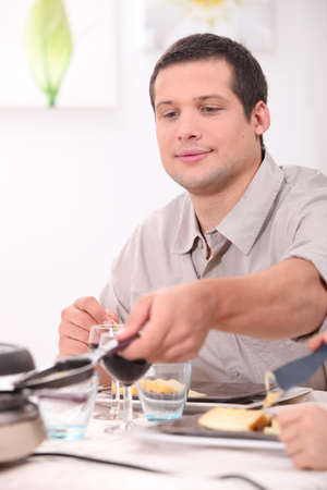 Man eating racletteの写真素材