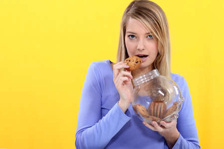 Cute blond eating cookies の写真素材
