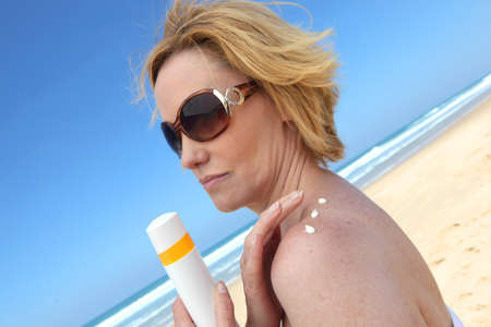 Woman putting on sun creamの写真素材