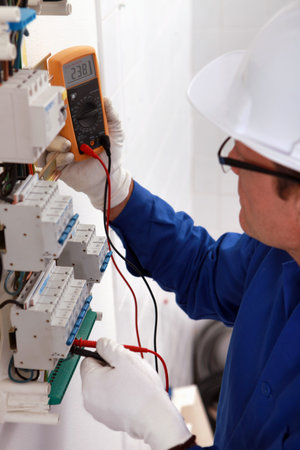 Man with a voltmeter in electrical panel