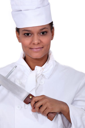 Female chef sharpening a knife