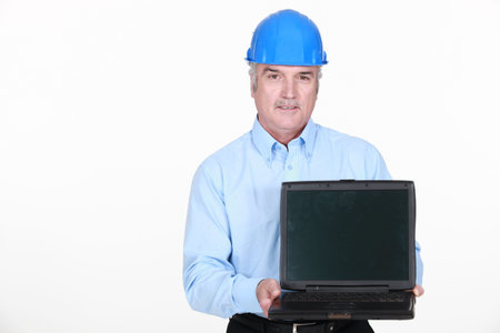 Architect stood holding portable computer