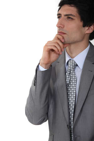 businessman thinking and holding his chinの写真素材