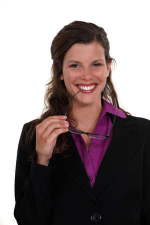 Woman nibbling at the frame of her glassesの写真素材