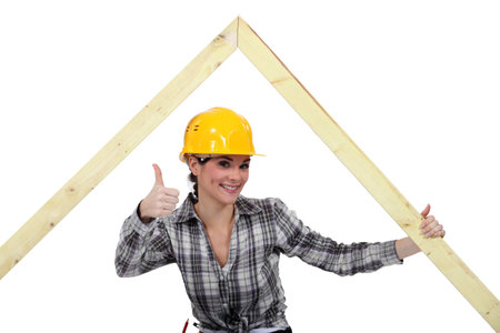 Positive female carpenter with wooden frame