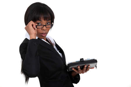 Businesswoman peering over her glassesの写真素材