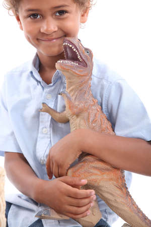 Little boy playing with toy dinosaurの写真素材