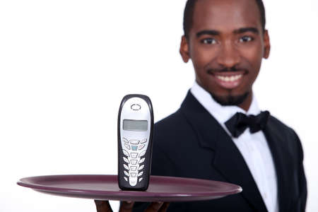 black waiter showing a phoneの写真素材