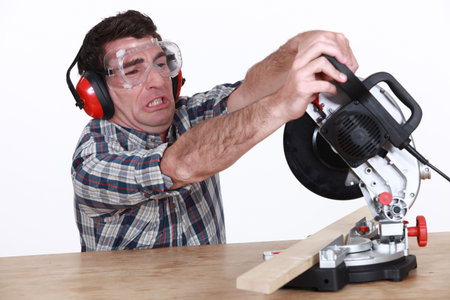 Man struggling to use a mitre saw