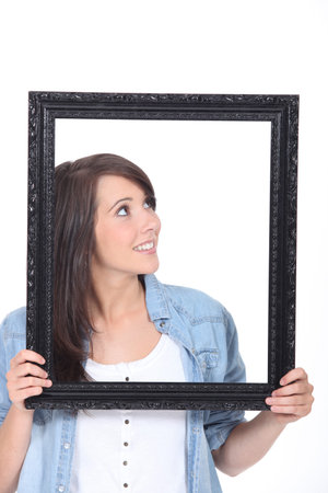 Woman stood holding empty picture frame