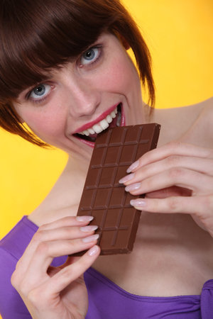 Woman eating chocolate barの写真素材
