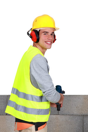 Man drilling into breeze blocks