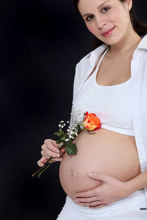Pregnant woman holding flowerの写真素材