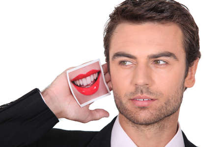 a business man with a mouth picture near his earの写真素材