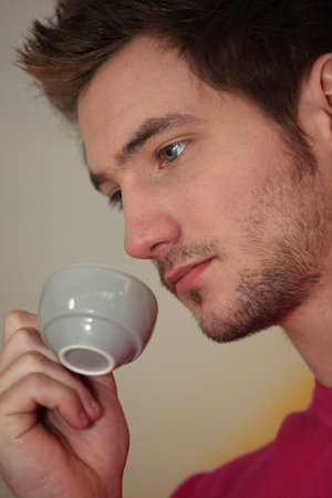 A pensive man drinking a cup of coffee