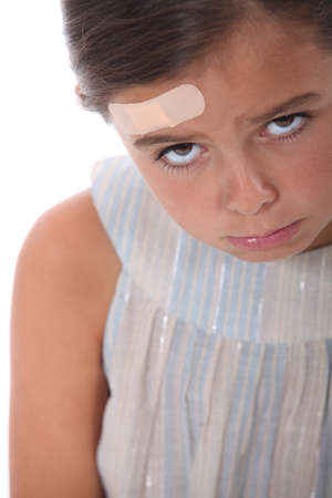 Girl with a wound on the foreheadの写真素材