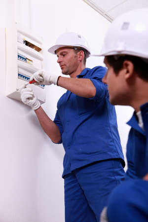 Tradesman repairing a distribution boardの写真素材