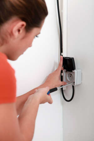 Woman repairing a plugの写真素材