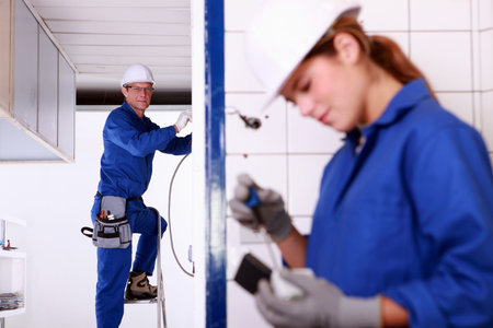 Mentor supervising female electrical engineer