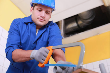 Plumber sawing plastic pipeの写真素材
