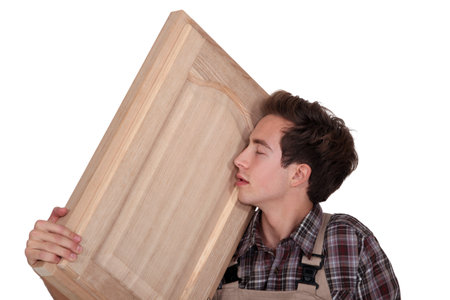 Man nuzzling a hand-crafted piece of woodの写真素材