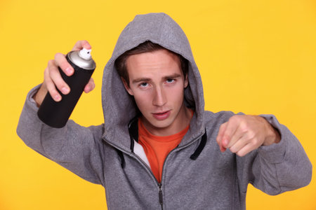 Hooded youth with paint canの写真素材