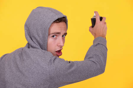 Young person spray painting wallの写真素材