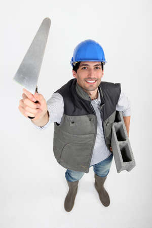 Bricklayer with trowel and cement blockの写真素材